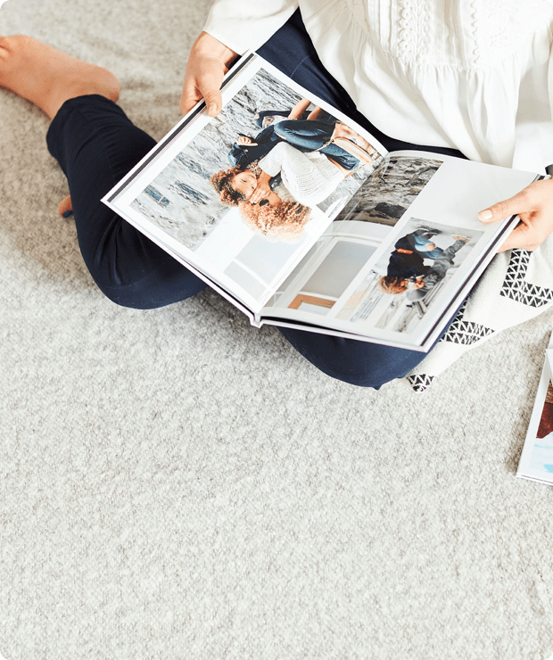 woman sitting on carpet holding a photobook open